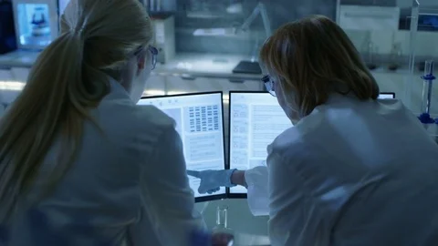 Senior Female Scientist Discusses Scientific Data with Her Laboratory Assistant. Stock Footage