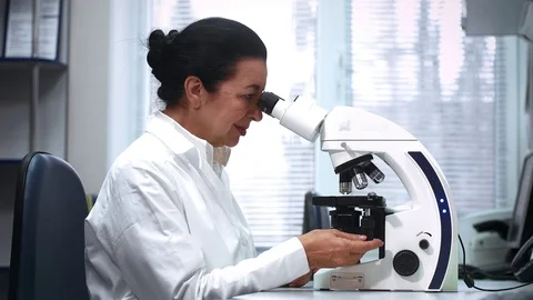 Senior Female Scientist Working on a Microscope at Her Lab Stock Footage 71778038