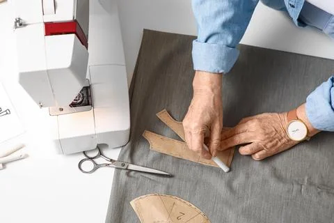 Senior female tailor making pattern on table in atelier, top view Stock Photos
