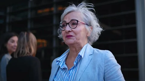 Senior formal grey haired pretty business woman walking empowered with cheerful Stock Footage 315879894