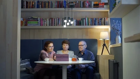 Senior Friends Converses while Using Tablet PC Stock Footage 122494066
