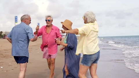 Senior friends having fun dancing on the beach Stock Footage 335694662