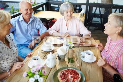 Senior friends having tea with dessert in cafe Stock Photos