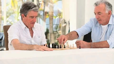 Senior friends men playing chess Stock Footage 1066931