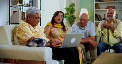 Senior friends using laptop together indoors while planning something fun Stock Footage 342386637