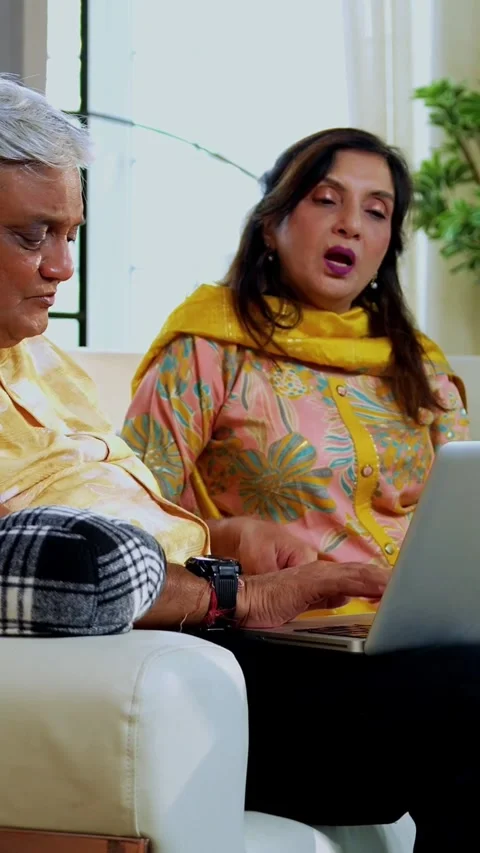 Senior friends using laptop together indoors while planning something fun Stock Footage 342387245