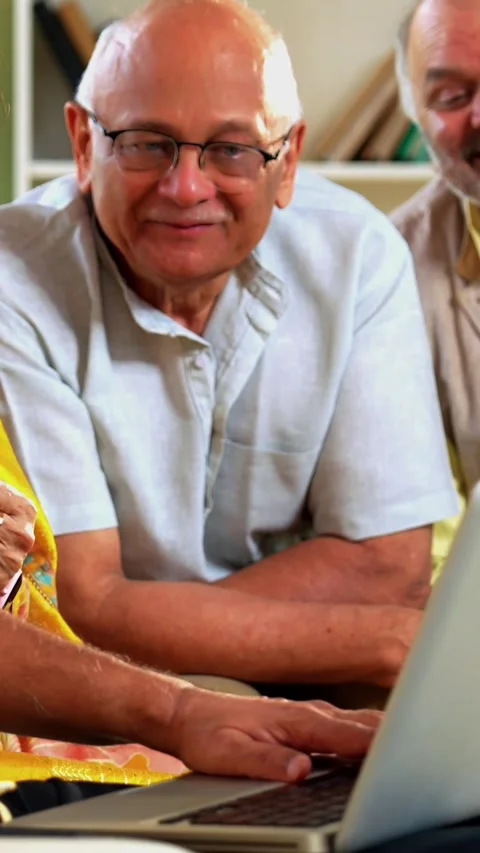 Senior friends using laptop together indoors while planning something fun Stock Footage 342387253