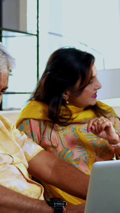Senior friends using laptop together indoors while planning something fun Stock Footage 342387254