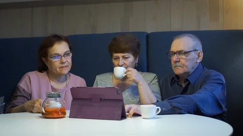 Senior Friends Using Tablet while Sitting in Cafe Stock Footage 123643560