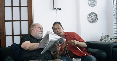Senior Gay Man Helping Husband Solve Crossword Puzzle Stock Footage 111663268