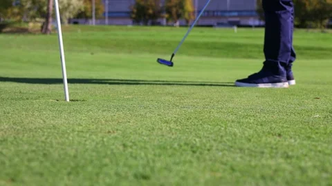 Senior golfer putting ball into hole on green close-up Stock Footage 292017170