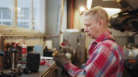 Senior gray-haired mechanic at work in an auto repair shop. Handsome Car Stock Footage 243710959