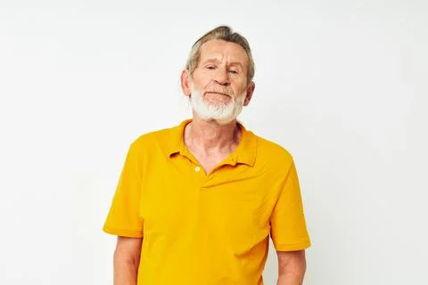 Senior grey-haired man with a gray beard emotion gestures hands light background Fotos Stock