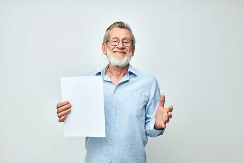 Senior grey-haired man holding a sheet of paper copy-space posing isolated Stock Photos
