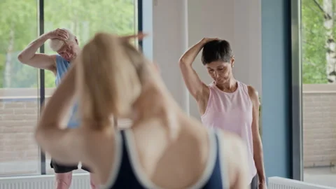 Senior Group Stretching in Yoga Class with Female Instructor Stock Footage 339857344
