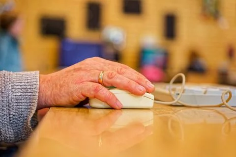 Senior hand using wired computer mouse symbolizing digital communication an.. Stock Photos