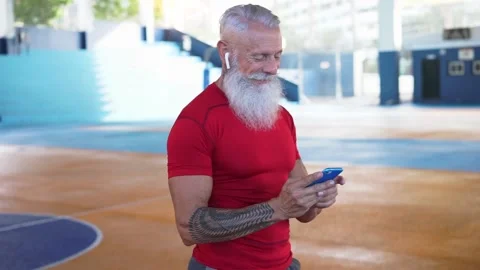Senior hipster athlete using smartphone after individual workout session Stock Footage 137440558