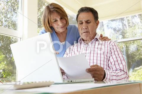 Senior Hispanic Couple Working In Home Office Stock Photos