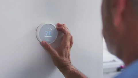Senior Hispanic Man Adjusting Digital Central Heating Thermostat In Home Stock Footage 131125936