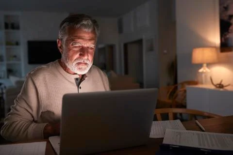 Senior Hispanic man checking his finances online at home using a laptop computer 写真素材