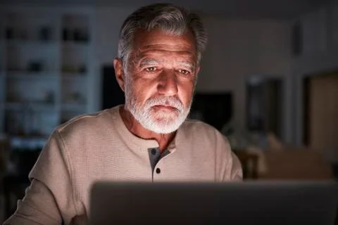 Senior Hispanic man checking his finances online at home using a laptop computer Stock Photos