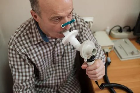 Senior hispanic man man testing breathing function by spirometry Stock Photos