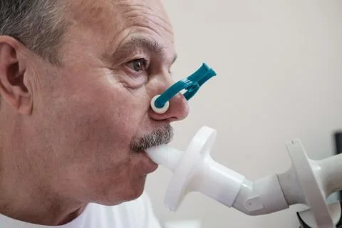 Senior hispanic man man testing breathing function by spirometry Stock Photos