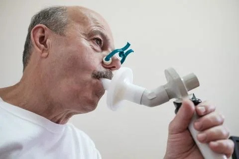 Senior hispanic man man testing breathing function by spirometry Stock Photos