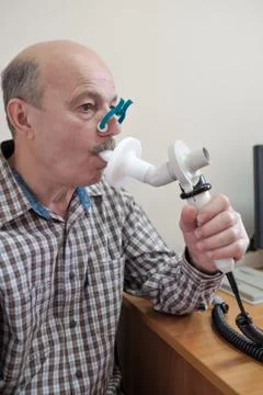 Senior hispanic man man testing breathing function by spirometry Stock Photos