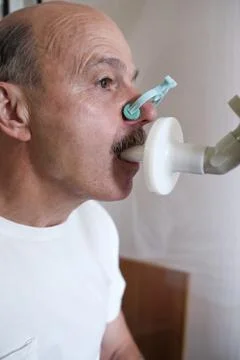 Senior hispanic man man testing breathing function by spirometry Stock Photos