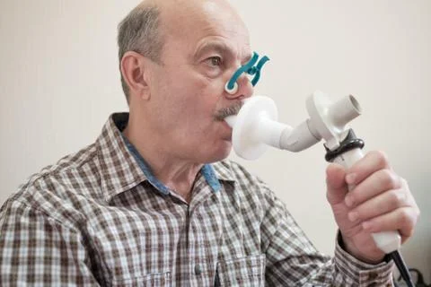Senior hispanic man man testing breathing function by spirometry. Stock Photos