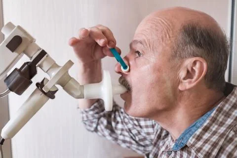 Senior hispanic man man testing breathing function by spirometry. Stock Photos