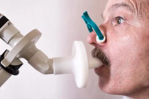 Senior hispanic man man testing breathing function by spirometry. Stock Photos