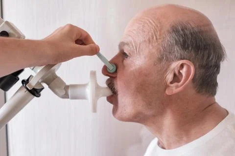 Senior hispanic man man testing breathing function by spirometry. Stock Photos