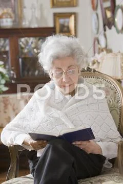 Senior hispanic woman reading book Stock Photos