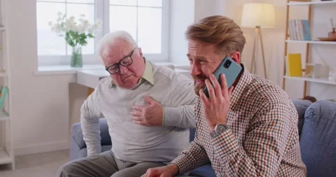 Senior at home having heart attack, suffering from chest pain, young man calling Stock Footage 345605526