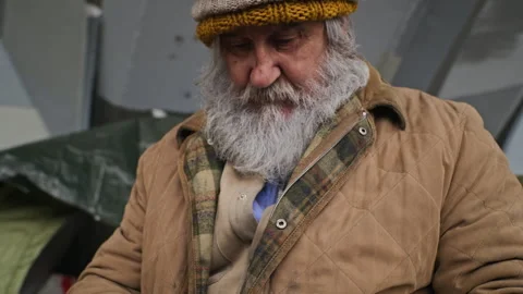 Senior Homeless Man Mending Torn Clothes with Needle Outdoors Stock Footage 345715086