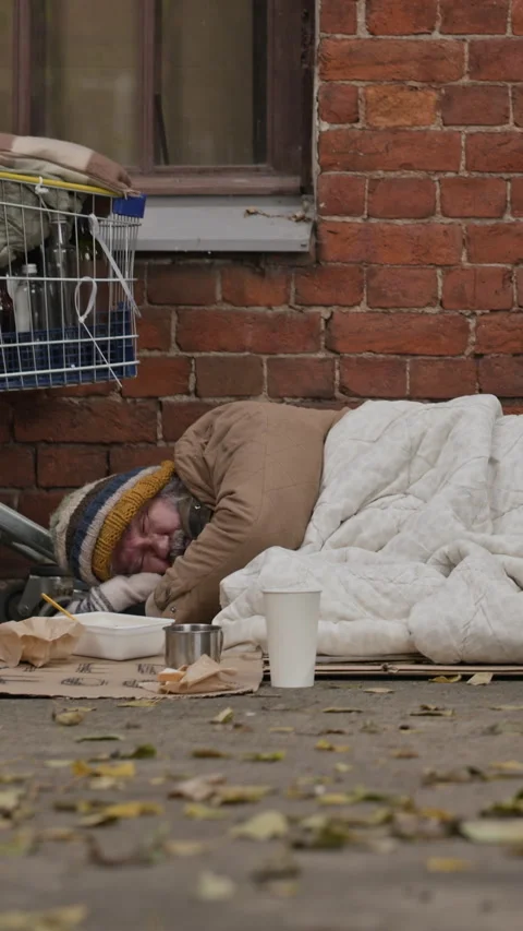 Senior Homeless Man Waking up on Ground of Cold City Sidewalk Stock Footage 345704662