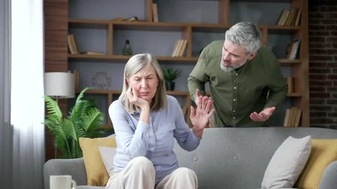 Senior husband shouting at his seated wife while emotionally intimidating her  스톡 동영상 339775903