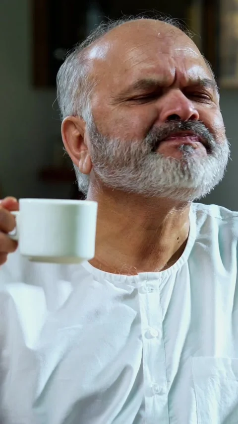 Senior Indian man sitting with snacks, reacting joyfully to tasty Stock Footage 343106956