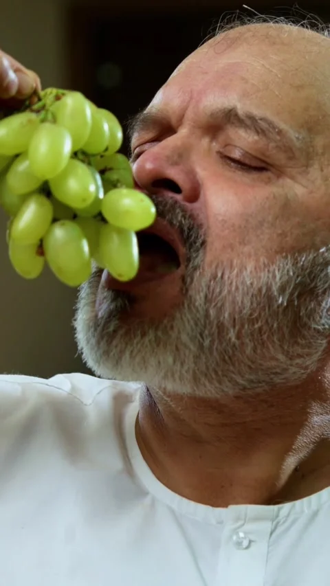 Senior Indian man sitting with snacks, reacting joyfully to tasty Video stock 343107098