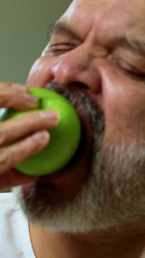 Senior Indian man sitting with snacks, reacting joyfully to tasty Stock Footage 343107116