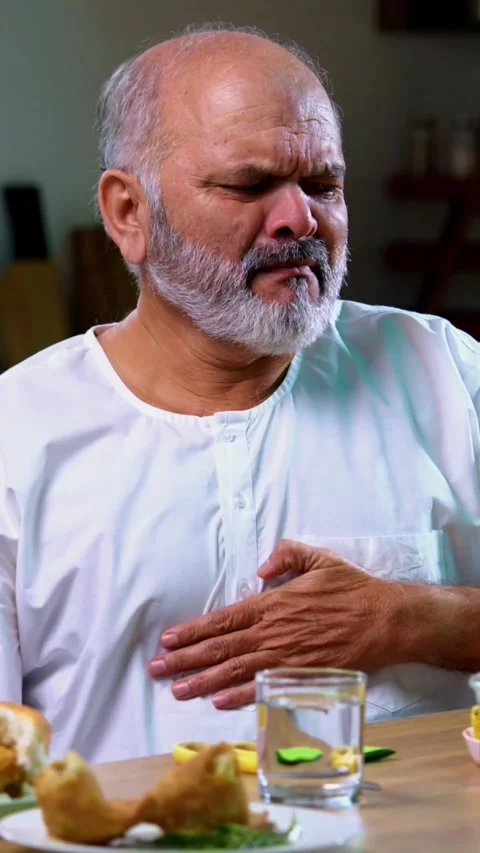 Senior Indian man sitting with snacks, reacting joyfully to tasty Video stock 343107247