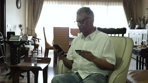 Senior Indian Man Using Smartphone and Credit Card For Online Shopping At H.. Видео 321627221