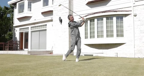 Senior Japanese man practicing golf in the garden Stock Footage 152196314