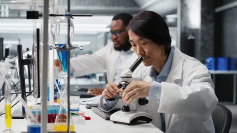 Senior lab engineer inspecting specimen slide for microscopy study Stock Footage 320728235