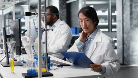 Senior laboratory scientist feeling neck ache while using PC to log patient data 스톡 동영상 320145873