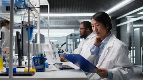 Senior laboratory scientist feeling neck ache while using PC to log patient data 스톡 동영상 320146168