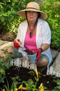 Senior lady doing yard work around the house Stock Photos