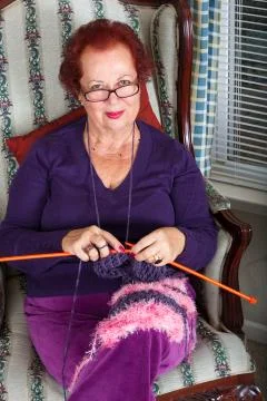 Senior lady looking at you while knitting Stock Photos